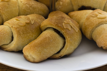 Small rolls with filling and almonds on the surface.