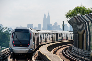 Mass Rapid Transit (MRT) train with background of cityscape in Kuala Lumpur. MRT system forming the major component of the railway system in Kuala Lumpur, Malaysia. - obrazy, fototapety, plakaty