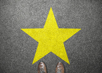 big yellow star on floor with businessman shoes