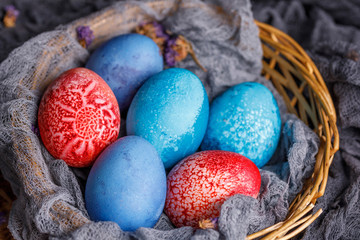 Easter eggs of unusual color in a wicker basket view from above. Still life of the holiday.