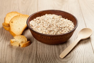 Oatmeal in bowl with Bread Slices on Table