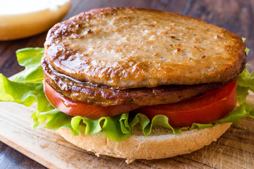 Open Double Burger with Turkey Meat, Lettuce and Tomatoes on Wooden Surface.