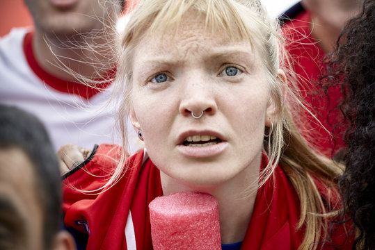 Woman watching football match with furrowed brow, portrait