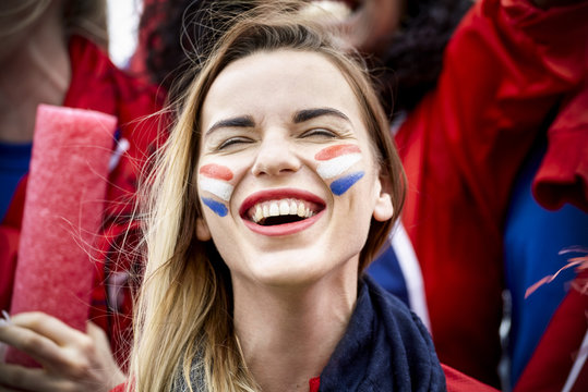French football fan smiling at match, portrait