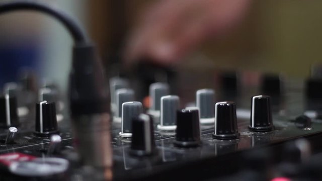 DJ uses the latest audio mixer at office building at the party.