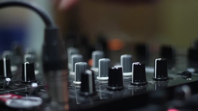 DJ uses the latest audio mixer at office building at the party.