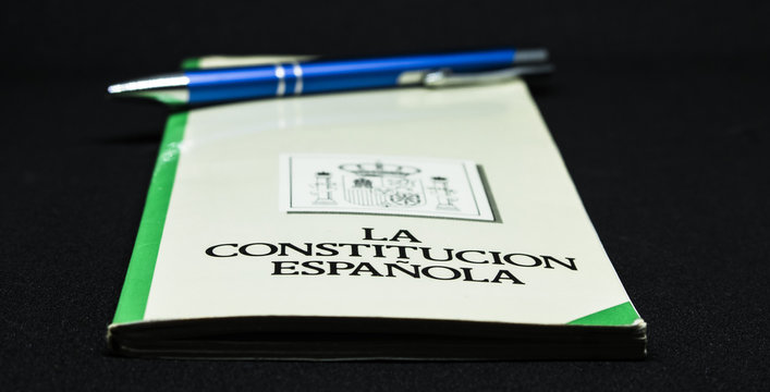 Book of the spanish constitution wiht a pen and the graphical white background - Powered by Adobe