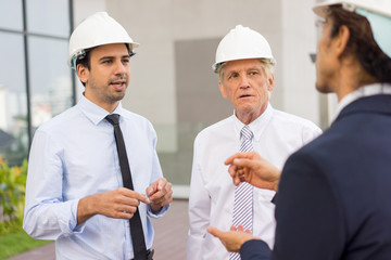 Three Diverse Architects Discussing Issue Outdoors