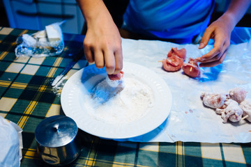 Fototapeta na wymiar hands prepare pieces of meat, put into flour to be cooked