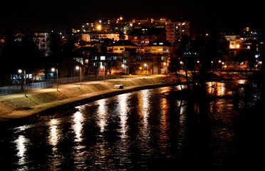 city on the river lit at night
