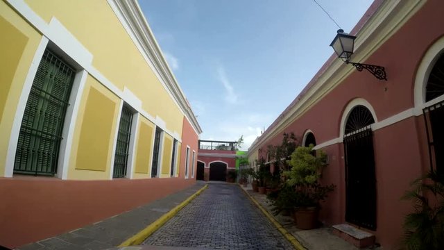 POV of Old narrow brick paved road and colonial houses in the old city of San Juan, Puerto Rico. Old San Juan is a main spot for local and internal tourism 