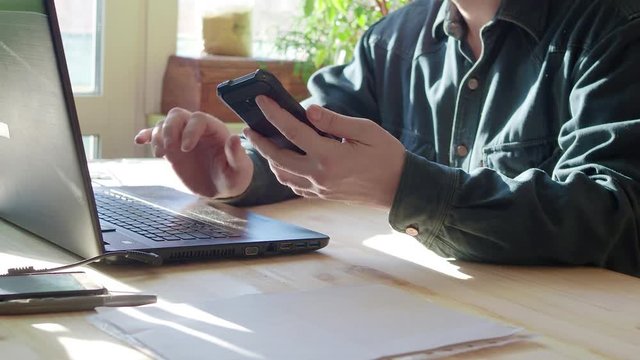 Man's hands using laptop with blank screen on desk in home interior