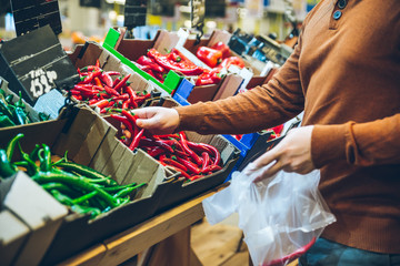 man choose red hot pepper in market