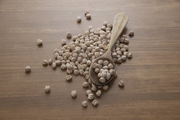 Garbanzos en mesa marrón con cuchara de madera