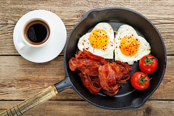 English breakfast - fried egg,tomatoes and bacon.top view