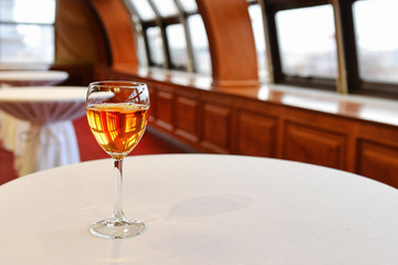 One glass of wine for a banquet in an empty hall. Free space