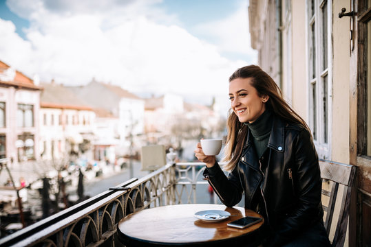 Young Woman Drinking Coffee On The Balcony.