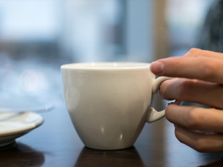White cup on the table, breakfast in a cozy cafe