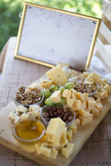 cheese, nuts and grapes on a wooden board