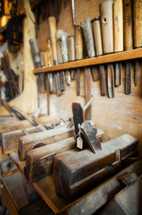 Fototapeta na wymiar Old vintage carpenter tools on the wall and bench of a dusty workshop