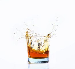 Isolated shot of whiskey with splash on white background, brandy in a glass