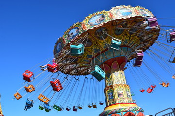 Colorful carnival ride at amusement park, summer day.