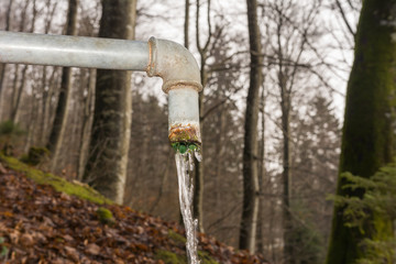 wasser fliesst in der natur aus Brunnen 