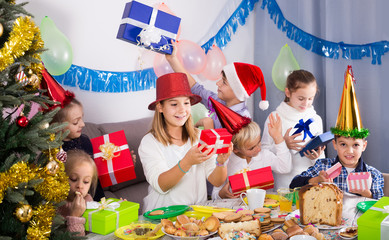children presenting gifts during Christmas dinner