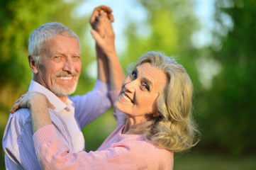 portrait of beautiful caucasian senior couple  in the park danci