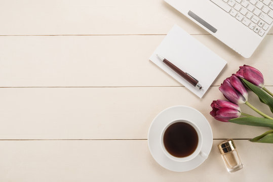 Office table with cup of coffee and flowers