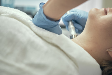 Obraz premium Microcurrent technology equipment. Body, face, decollete, chin, nose, forehead. professional skin care in a cosmetology salon. Beautiful, clean skin