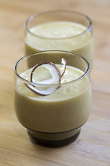 Pineapple smoothie with bananas, oatmeals and coconut milk, decorated with coconut chips