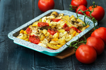 stewed potatoes and ripe tomatoes on a wooden background