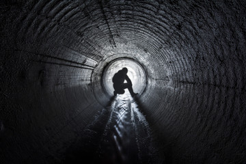 Men seating in underground tunnel 