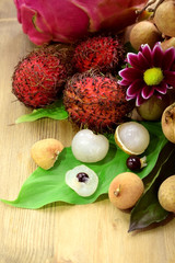 Bunch of longan, rambutan and pitahaya on wooden background. Set of Asian tropical fruits