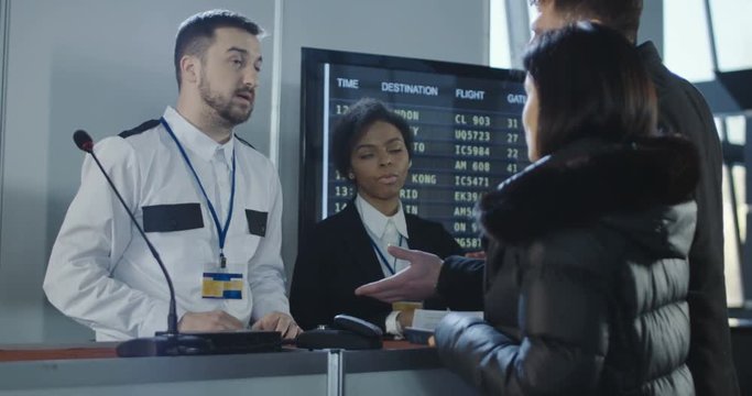 Businesspeople at counter of registration in airport arguing with multiracial officers because of visa refusal. 4K shot on Red cinema camera.