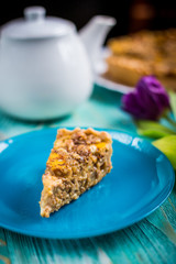 Pumpkin pie on a blue background with a teapot and flowers