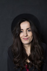 Happy tender girl. Photo of gorgeous young brunette woman  in black hipster hat