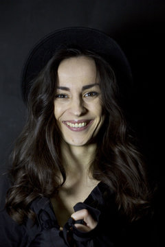 Happy tender girl. Photo of gorgeous young brunette woman  in black hipster hat