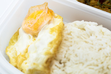 Cost-up Thai food menu is Stir Fried Minced Chicken Breast with Hot Yellow Curry Paste Served with Rice and Fried Egg box set isolated on white background. It copy space and selection focus.