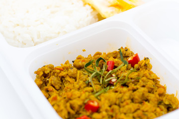 Cost-up Thai food menu is Stir Fried Minced Chicken Breast with Hot Yellow Curry Paste Served with Rice and Fried Egg box set isolated on white background. It copy space and selection focus.