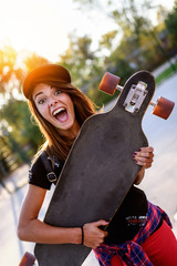 Cute urban girl holding skateboard in skatepark © lordn