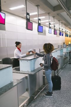 Airline check-in attendant handing passport to commuter