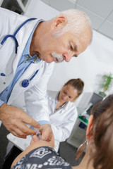 Obraz na płótnie Canvas senior doctor doing injection