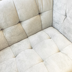 Corner of a shiny white velvet sofa