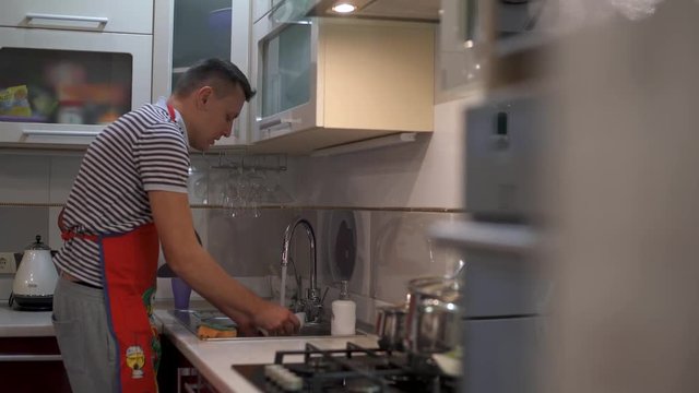 The man was washing the dishes. Close up of hands and crane.