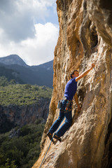 Fototapeta premium rock-climber climbs route with lower insurance 