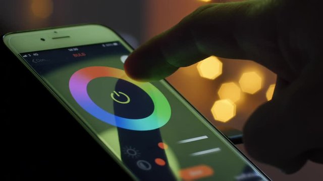 Smart home lighting technology, controlling color of a bulb and scheduling time with a smart phone. Remote controlling light with a phone app. 4k Video