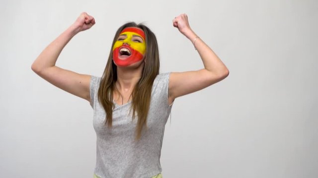 Pretty woman supporter fan of Portugal national team painted flag face get happy victory screaming into a camera. Football emotions.