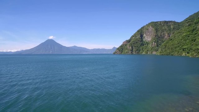 Aerial over  Lake Amatitlan in Guatemala reveals the Pacaya Volcano in the distance.